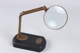 A BRASS ADJUSTABLE MAGNIFYING GLASS ON STAND, 6in wide.