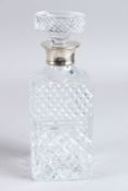 A CUT GLASS WHISKY DECANTER AND STOPPER with silver rim. London 1930.