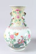 A LARGE CHINESE FAMILLE ROSE BULBOUS VASE painted with flowers, with applied fruit handles. Possibly