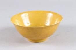 A CHINESE YELLOW GLAZED CIRCULAR BOWL with incised decoration. 6ins diameter