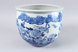 A CHINESE BLUE AND WHITE JARDINIERE, the sides with begonias and birds. 9ins high x 11ins diameter.