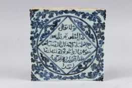 A CHINESE BLUE AND WHITE POTTERY TILE, decorated with Islamic calligraphy, 7¾in wide.