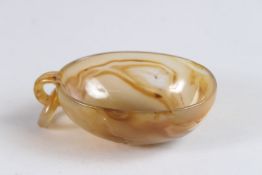 A CHINESE CARVED JADITE LIBATION CUP oval shape with with ring handle. 3.75ins wide.