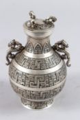 A CHINESE WHITE METAL TWO HANDLED VASE AND COVER, with Kylin handles and incised decoration. 7ins