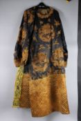 A CHINESE ROBE, black ground with gilt metal thread embroidered dragons.