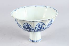 A CHINESE BLUE AND WHITE LOTUS SHAPED STEM CUP, painted with panels of dragons, 6½in diameter.