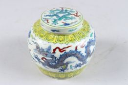 A CHINESE WUCAI GINGER JAR AND COVER, painted with dragons, 4½in high.
