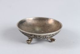 FOUR VARIOUS SILVER METAL COIN DISHES with dragons, snakes, monkeys and other motifs. 3.75ins