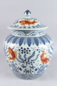 A GOOD, LARGE, CHINESE UNDERGLAZE RED AND BLUE JAR AND COVER, painted with fish and algae, 17in
