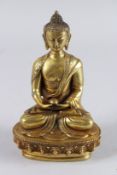A BURMESE GILT BRONZE SEATED DEITY on an oval base. 8ins high.