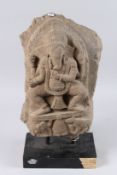 A FINELY CARVED 10TH - 12TH CENTURY INDIAN, OR SOUTH EAST ASIAN, STONE FIGURE OF GANESH, on a stand.