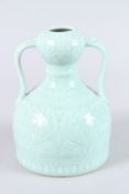 A CHINESE CELADON GLAZE TWIN HANDLED PORCELAIN JAR, the body with moulded decoration, square seal