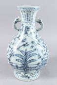 A LARGE CHINESE BLUE AND WHITE VASE, with elephant head handles, tree and fence decoration to the