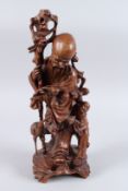 A CHINESE CARVED WOODEN SAGE, a young boy and bird at his side. 16ins high.