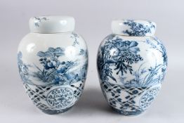 A PAIR OF 20TH CENTURY JAPANESE BLUE AND WHITE JARS AND COVERS, with pierced bodies painted with a