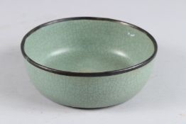 A CHINESE CELEDON GLAZED CIRCULAR BOWL calligraphy inscription to the base. 6.75ins diameter.