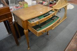 An oak two drawer floor standing cutlery canteen containing twelve place King pattern canteen of