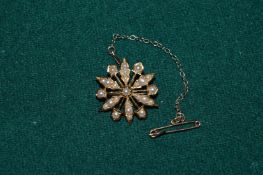 A 15ct gold and seed pearl star shaped brooch.