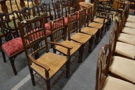 A set of six rush seated spindle back dining chairs, two with arms.