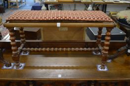 A walnut and cane seated long stool.