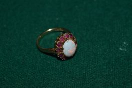 A yellow metal, ruby and moonstone ring.