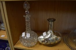 Cut glass decanter and a silvered glass bottle.