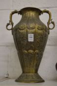 A good Islamic embossed and engraved twin handled brass vase.