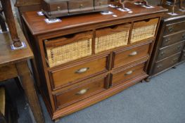 A modern storage unit with three basket drawers above four small drawers.