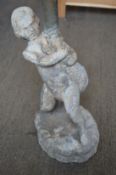 A lead garden fountain modelled as a young boy holding a dolphin.