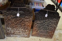 A pair of small cast iron fire backs.