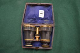 A leather cased pair of opera glasses.