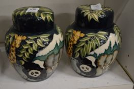 A pair of Moorcroft Noah's Ark ginger jars and covers decorated with African animals.