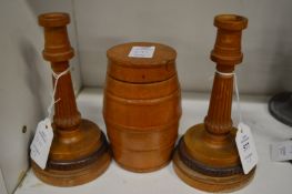 A pair of turned wood candlesticks together with a turned wood barrel shaped box and cover.