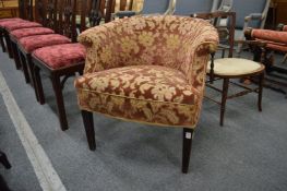 An upholstered horseshoe shaped armchair.