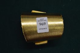 A designer gilt metal cuff bangle.