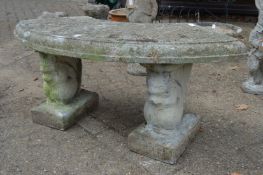 A reconstituted stone semi-circular garden seat with squirrel supports.