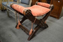 A carved oak and upholstered X shaped stool.