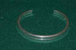 A silver bangle.