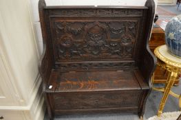 A carved oak hall settle.