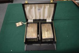 A cased pair of brushes.