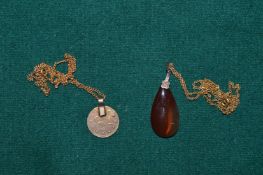 Two decorative pendants and chains.