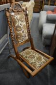 A walnut and upholstered folding chair.