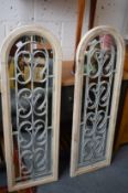 A pair of painted arched top mirrors with wrought iron decoration.