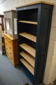 A blue painted and polished oak open bookcase.