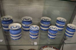 A collection of T G Green blue and white Cornish ware storage jars and covers, some named to include