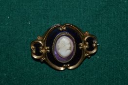 A yellow metal mourning brooch, the centre set with a portrait cameo of a young lady.