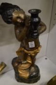A cast bronze and painted figure of a young boy holding a vase.