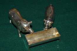 An unusual three piece condiment set modelled as two pigs and a trough.