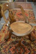 A Victorian walnut and cane seated swivel office chair.