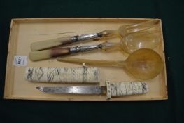 A bone mounted Japanese tanto and horn salad servers and another horn spoon.